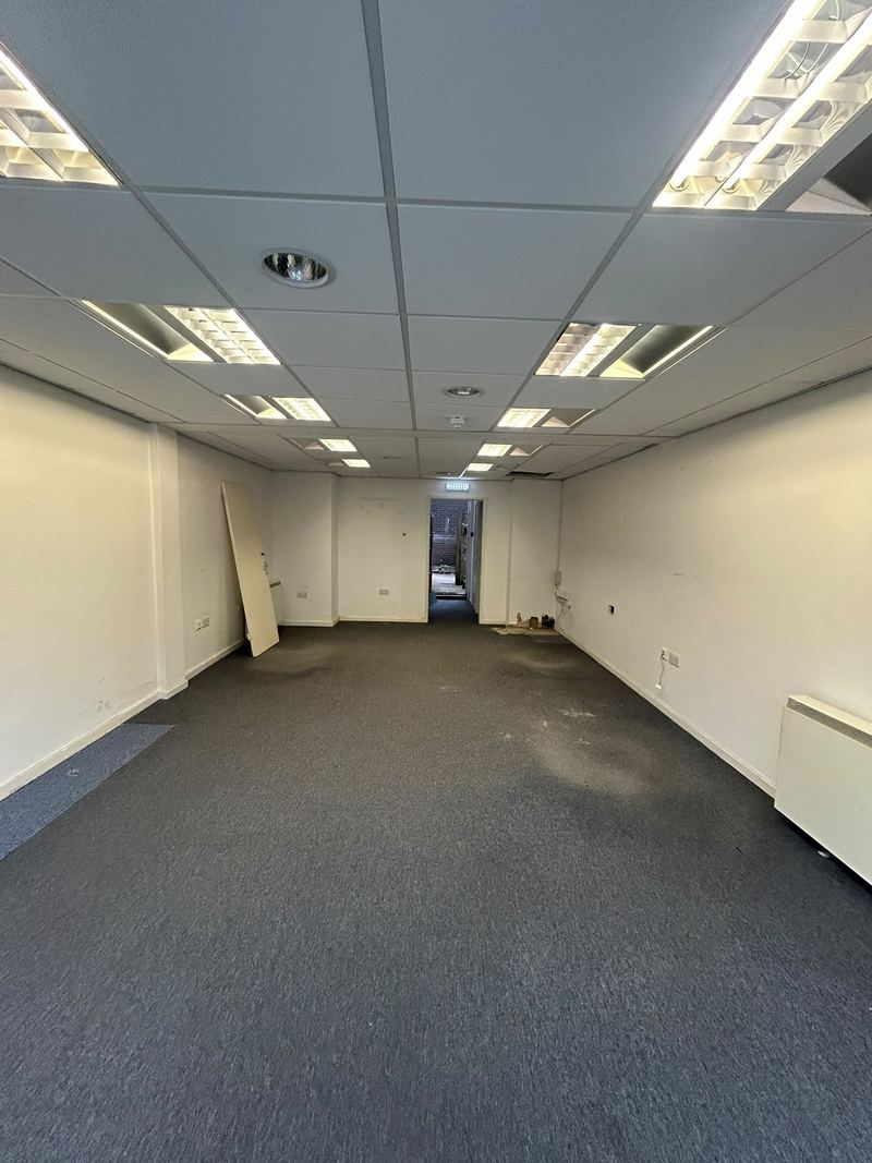 Before: a dated office unit with a grid ceiling and carpet tiles